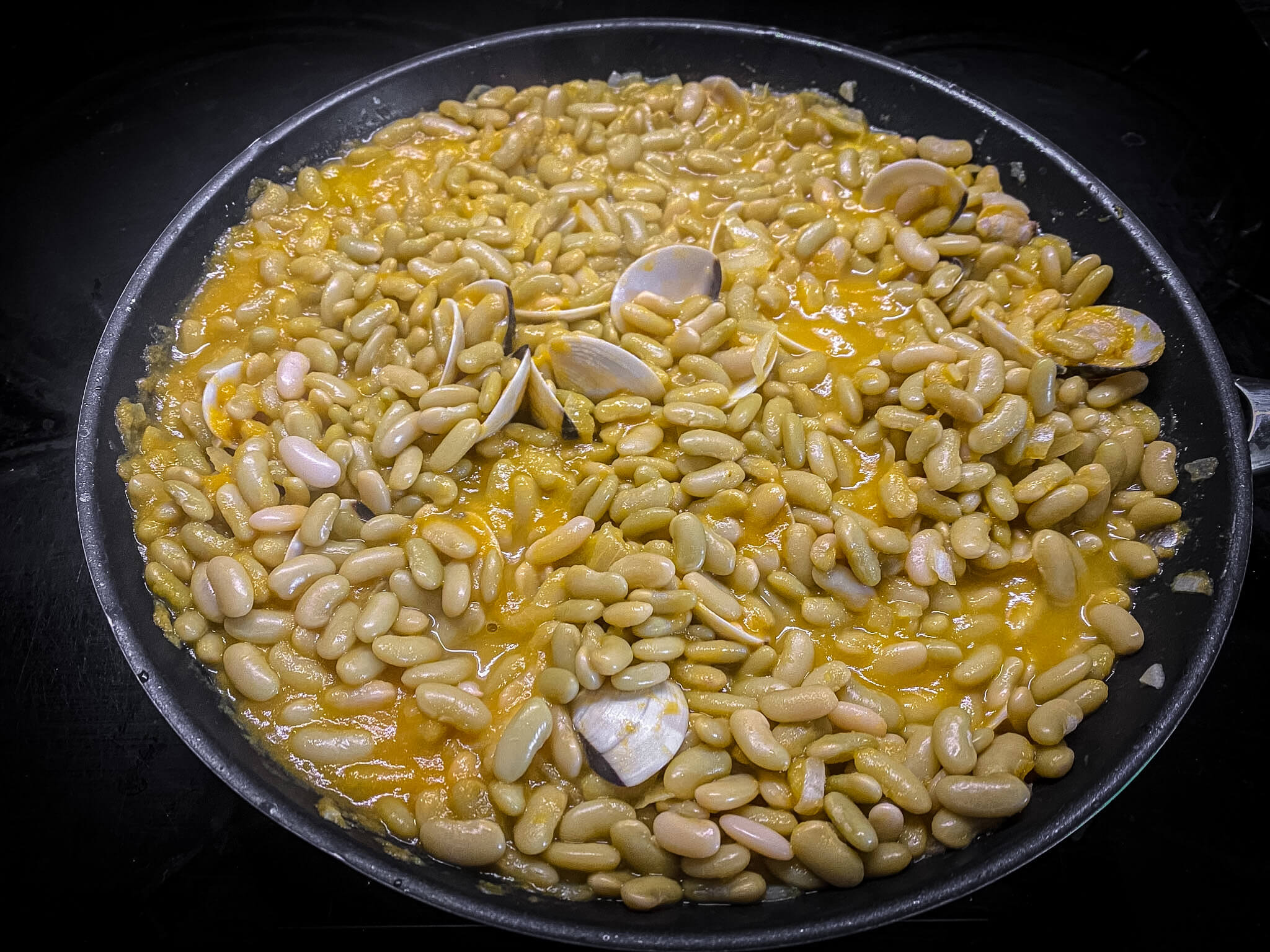 Traditional Asturian Verdinas Beans with Fresh Clams - Combining Green Beans with Clams in Skillet