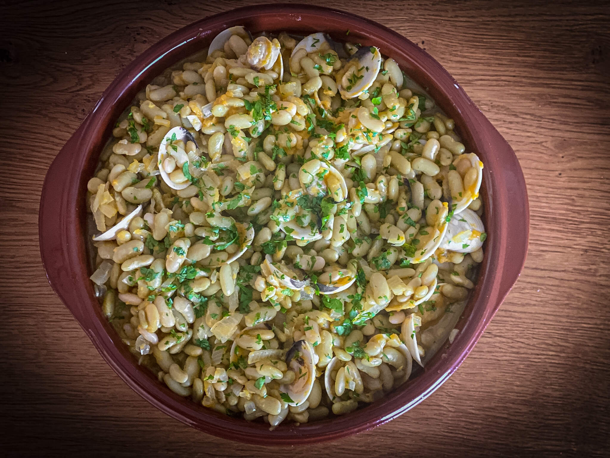 Traditional Asturian Verdinas Beans with Fresh Clams - Overhead View of Clay Bowl Presentation